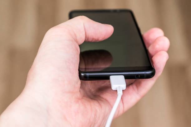 istock Phone with charger in hand 1319654879