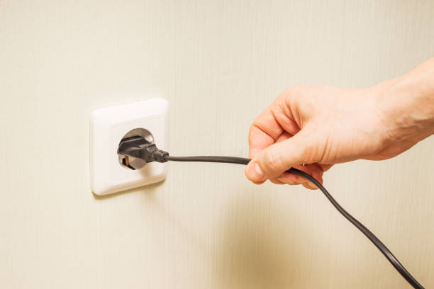 istock A person hand pulls an electrical cord plugged into a power outlet 1319655986
