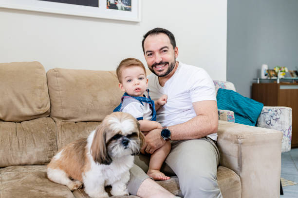 istock Father and son sitting on the sofa with their pet 1319656782