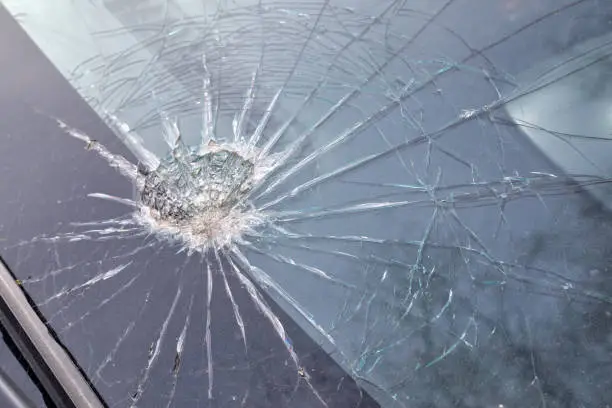 Broken windshield of a car, web of splits on the triplex windscreen. The consequences of hitting the glass.effect for design element