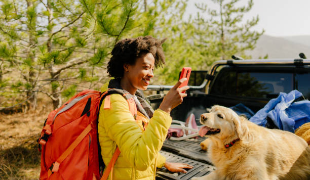 istock Young woman using mobile phone while on a road trip 1319657655