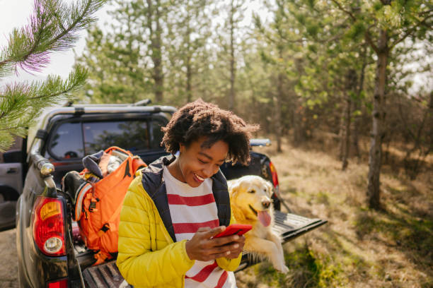 giovane donna che usa il cellulare durante un viaggio - outdoor equipment foto e immagini stock