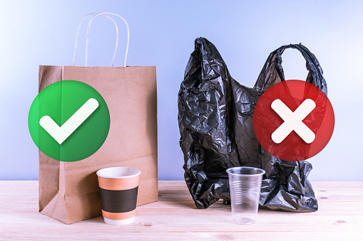 Bolsa de papel y taza de papel vs bolsa de plástico y vaso de plástico. Concepto de elección ambiental. photo