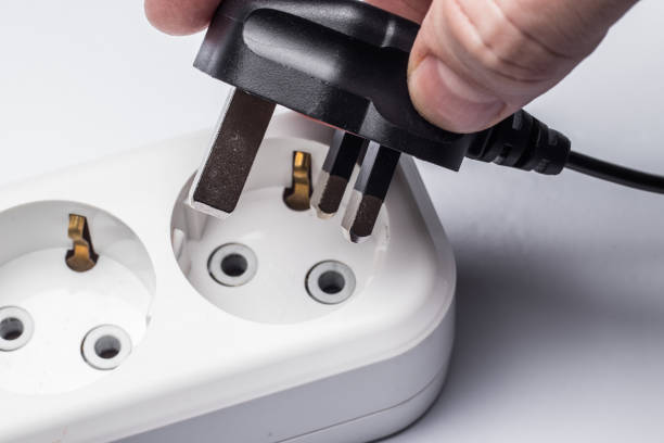 istock Different standards for electrical outlets. Unsuitable connector and plug in the hand of a person. Incompatibility, concept 1319659761