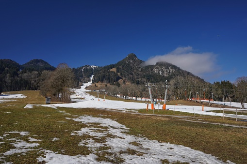 View the Alps and meadows with melting snow near Brauneck skiing area in Lenggries, South Bavaria.