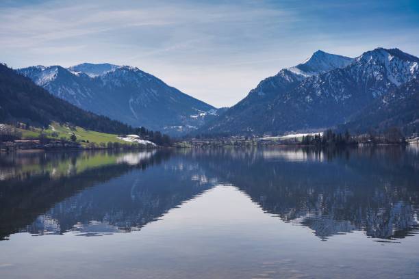 istock Alpine lake with the mountains partially covered by snow. 1319660541
