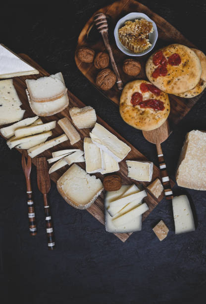 tabla de quesos con rodajas de queso en una tabla de cortar de madera. vista superior con texto de espacio de copia - cheese still life tray french cuisine fotografías e imágenes de stock