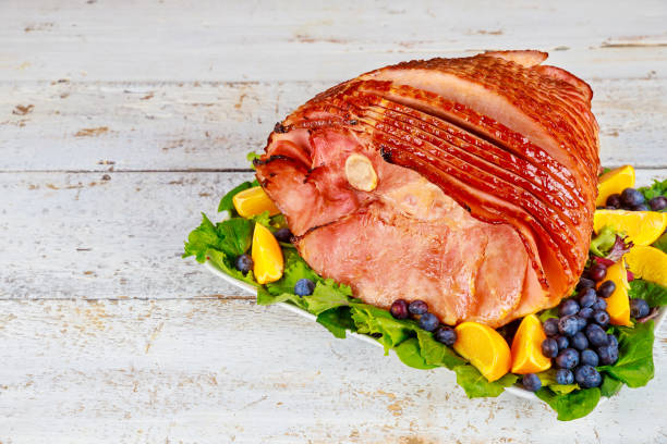 istock Spiral sliced hickory smoked ham with fresh orange and blueberries. 1319662432