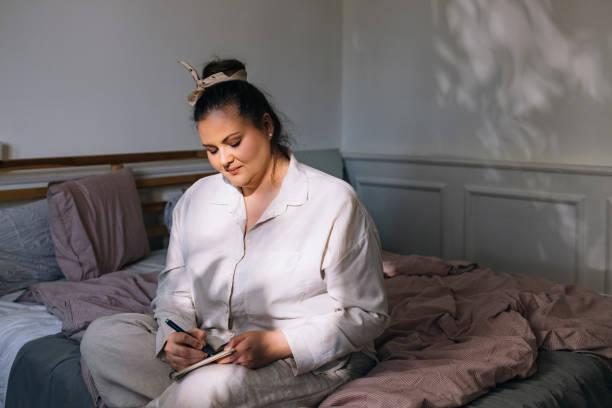 Plus Size Woman Sitting on Her Bed and Writing
