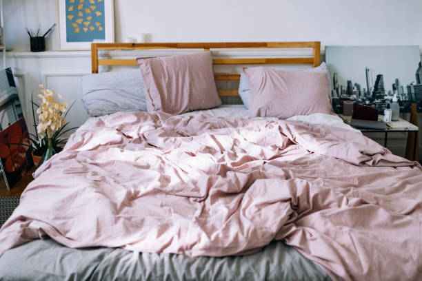 interni moderni: camera da letto con biancheria da letto rosa - lenzuolo foto e immagini stock