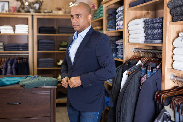 istock Man choosing suit jacket in clothing store 1319663314
