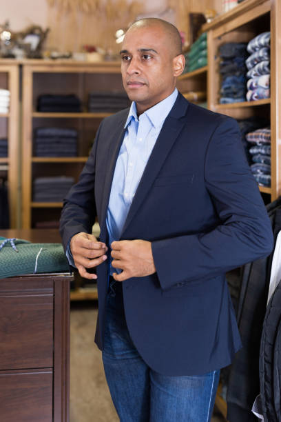 istock Man choosing suit jacket in clothing store 1319663317