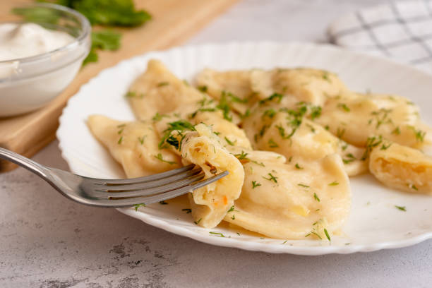 istock Potato dumplings sprinkled with dill on a white plate. Served with sour cream 1319667044