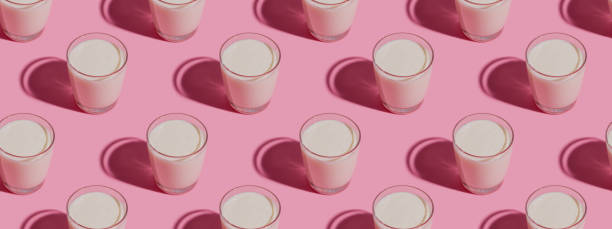 istock World Milk Day. Pattern on a  pink background. A glass of milk. Pattern. Banner 1319668870
