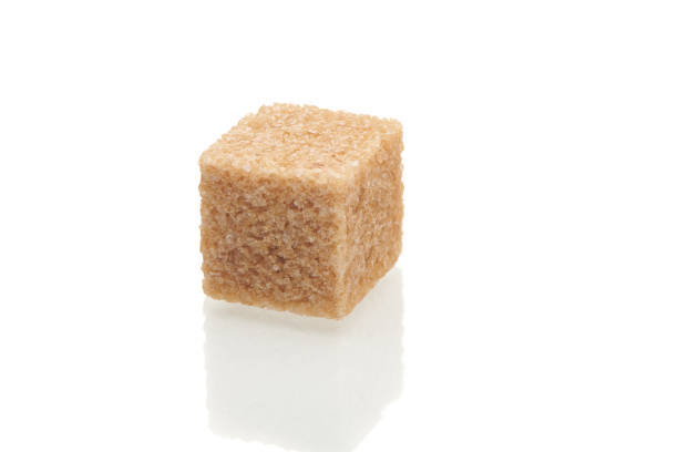 Sugar lumps piled up together against a black background