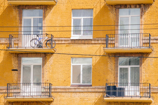 balconi e finestre su una casa in mattoni gialli - apartment building exterior urban scene window foto e immagini stock