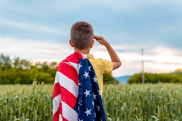 un joven saludando al ejército estadounidense y por el día de los caídos - child patriotism saluting flag fotografías e imágenes de stock