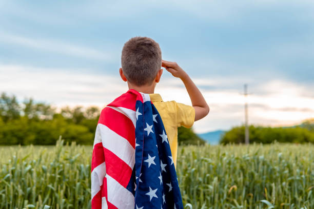młody chłopiec pozdrawia wojsko usa i na dzień pamięci - child patriotism saluting flag zdjęcia i obrazy z banku zdjęć