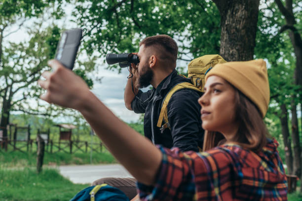istock Young hikers in nature using smartphone and binocular for finding the path in the forest 1319675287