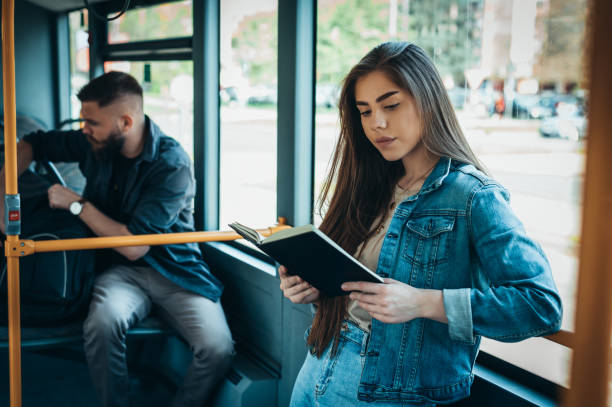 istock Young beautiful woman reading a book in a bus 1319675295