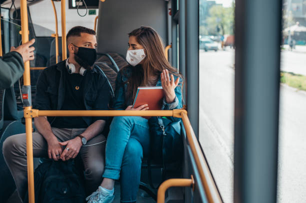 istock Young couple wearing protective masks riding a bus 1319675298