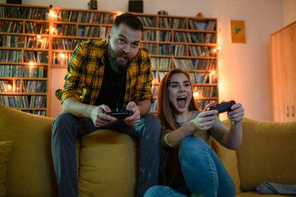 istock Young fun couple playing video games at home 1319675324