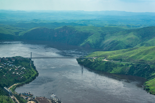 Aerial view of the Matadi suspension bridge in the town of Matadi. This bridge is the only bridge over the Congo River from the river mouth up to more than 3800 km. The bridge was built in 1983 by Japanese companies and has a span of 520 m. Matadi is the chief sea port of the Democratic Republic of the Congo and the capital of the Kongo Central province. Matadi serves as a major import and export point for the whole nation. Chief exports are coffee and timber. The town was founded in 1879 by Sir Henry Morton Stanley.