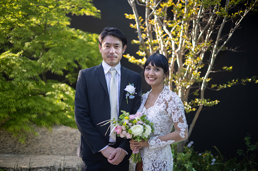 Indonesian woman and Japanese man having Islam style wedding ceremony and wedding party in Tokyo, Japan. Bride and groom, and participants are wearing face mask in most of the time to protect against coronavirus.