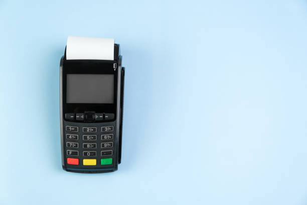 istock Payment terminal POS with a roll cash tape on the blue background with copy space 1319680252