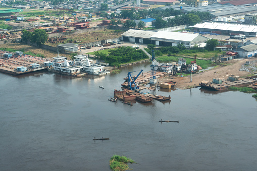 Kinshasa, Democratic Republic of Congo - December 13, 2014:\nAerial view of the river port, docks and simple shipyards on the banks of the Congo River in the outskirts of the Congolese capital Kinshasa. The Congo River is the most important and often the only means of transporting goods and people in the Congo.