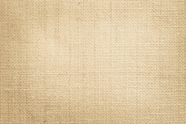 Jute hessian sackcloth canvas woven texture pattern background in light beige cream brown color blank empty