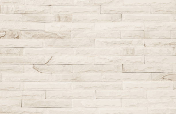 istock Empty Background of wide cream brick wall texture. Old brown brick wall concrete or stone pattern nature, wallpaper limestone abstract floor/Grid uneven interior rock. Home & office design backdrop. 1319689290