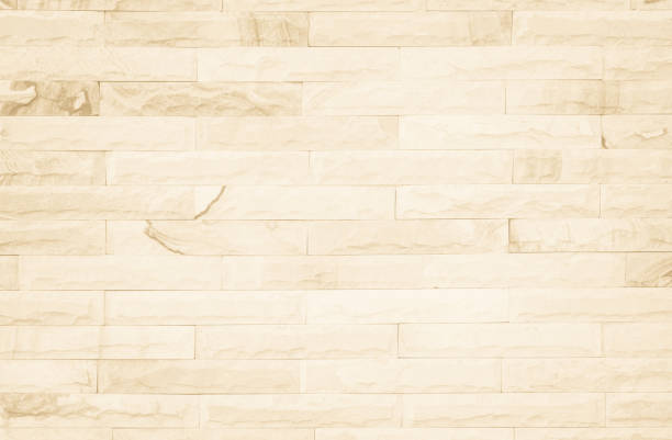 istock Empty background of wide cream brick wall texture. Beige old brown brick wall concrete or stone textured, wallpaper limestone abstract flooring/Grid uneven interior rock. Home decor design backdrop. 1319690501