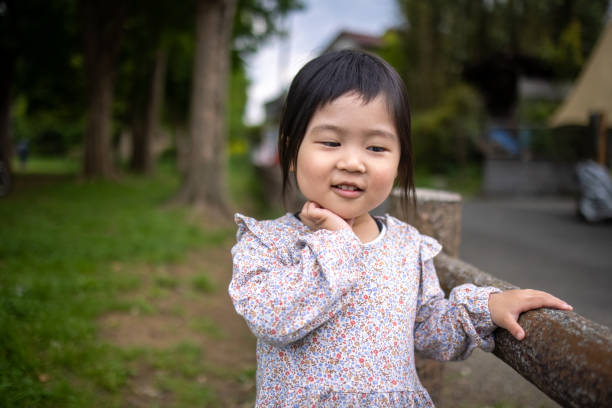 istock Little daughter standing in public park 1319691227