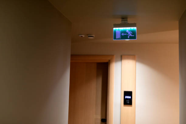 Green emergency exit sign on ceiling inside of building Green emergency exit sign on ceiling inside of building emergency exit photos stock pictures, royalty-free photos & images