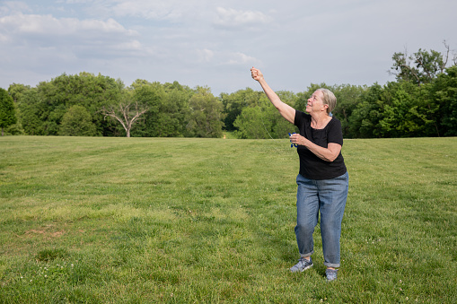 Seniors have fun while flying kite outdoors at park