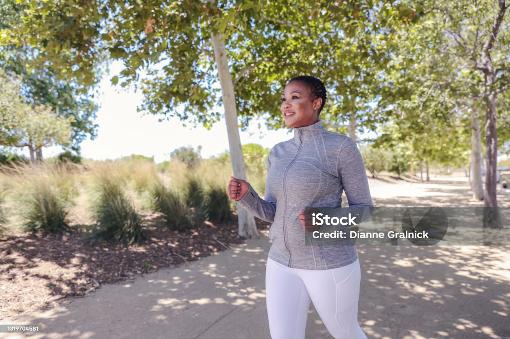 Attractive black woman exercising in nature Attractive black woman working out Racewalking Stock Photo