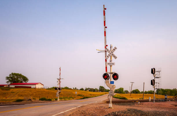 frühmorgens bahnübergang - railroad crossing train railroad track road sign stock-fotos und bilder