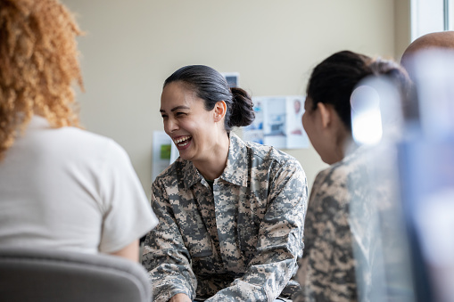 Adult military woman smiling during group therapy discussion