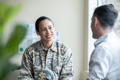 A young female soldier talks with a military counselor. The counselor takes notes while talking with the soldier.