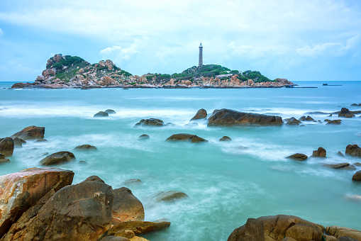 Ke Ga Lighthouse with surf patted smoother reefs create clouds on the sea as this is the only ancient lighthouse is located on the island in Vietnam