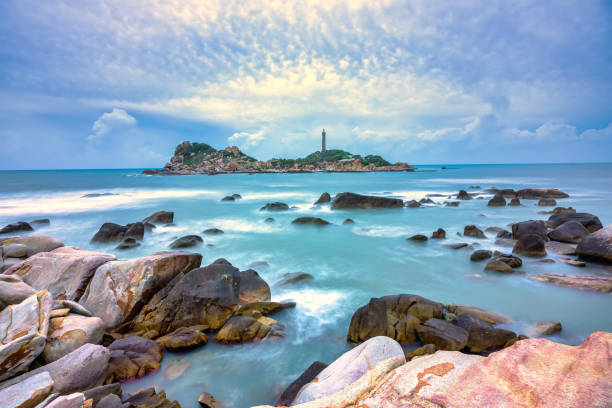 faro di ke ga con barriere coralline più lisce accarezzate dal surf - long exposure rock cloud sky foto e immagini stock