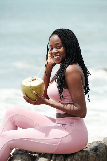 Fit woman drinking coconut cocktail