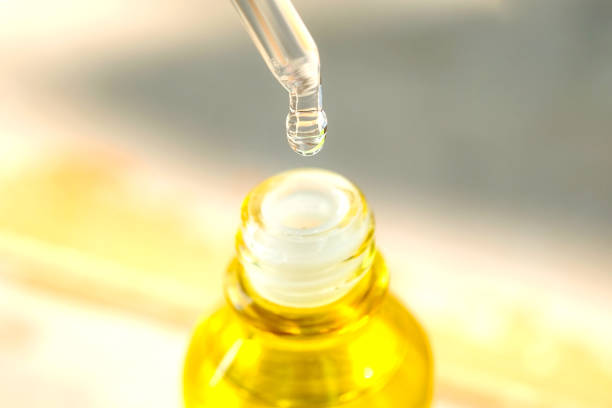 istock Dropping serum collagen moisturizer of face into clear yellow bottle soft light background. Protector skin Treatment facial essence oil, Vitamin C. Beauty and spa Concept 1319722019