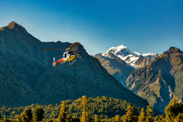 вертолет улетает к леднику в горах - franz josef glacier стоковые фото и изображения