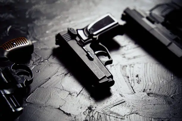 Photo of Three guns on black table.