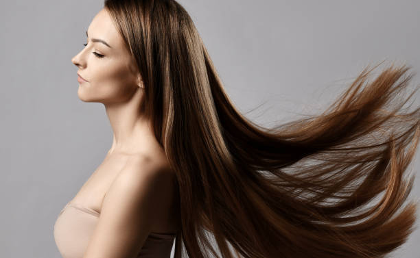 perfil de una joven con sujetador ajustado con los ojos cerrados y el pelo largo y sedoso que vuela revoloteando en el viento - cabello largo fotografías e imágenes de stock