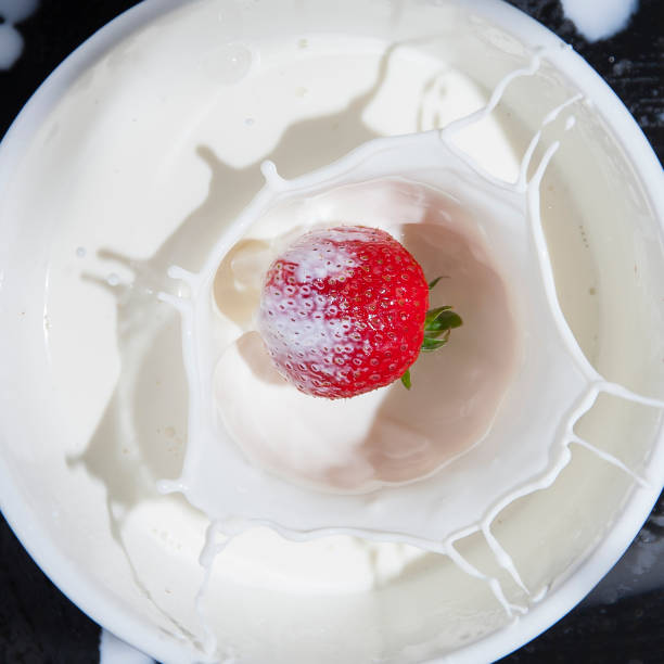 istock Fresh red strawberry falling into milk with a splash 1319729167