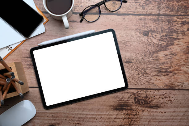 istock Mock up digital tablet with blank screen on wooden desk. Top view. 1319732067