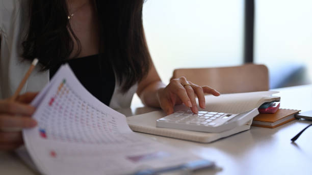 istock Cropped shot of accountant using calculator and analyzing finance data on office desk. 1319732113